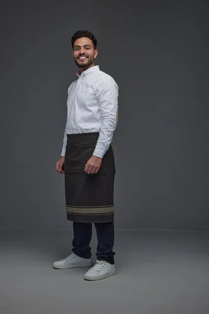 Saudi Waiter in Apron Smiling in Gray Studio Portrait