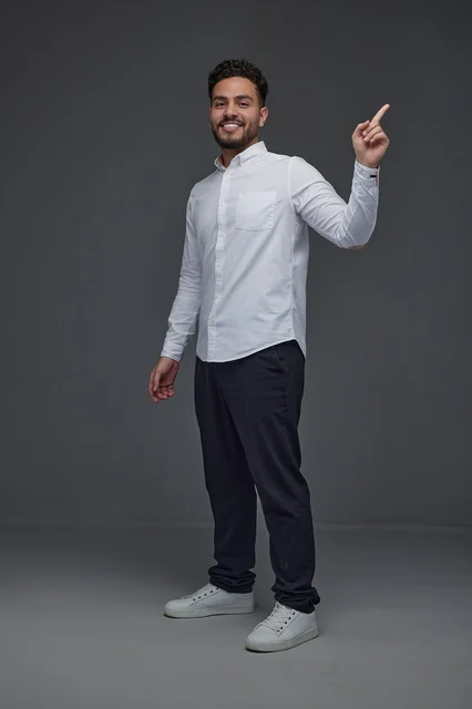Saudi Man Pointing Up Against Grey Studio Background