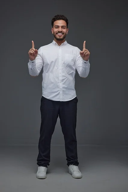 Smiling Saudi Man Pointing Upwards in Studio Portrait