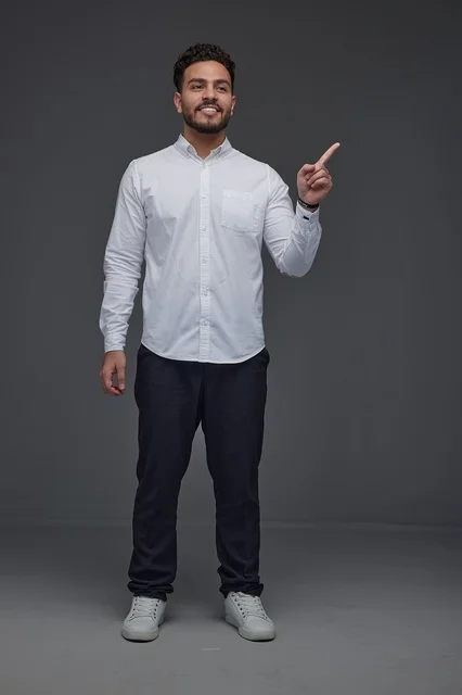 Smiling Saudi Man Pointing Finger in Studio Portrait