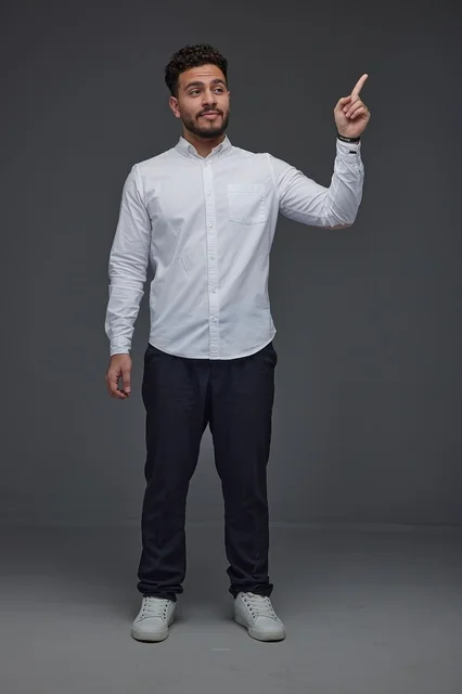 Saudi Man Pointing Upward on Grey Background