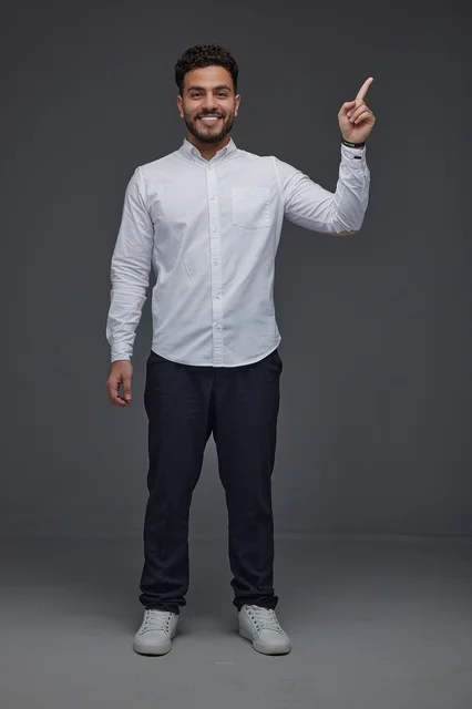 Smiling Saudi Man Pointing Up on Gray Background