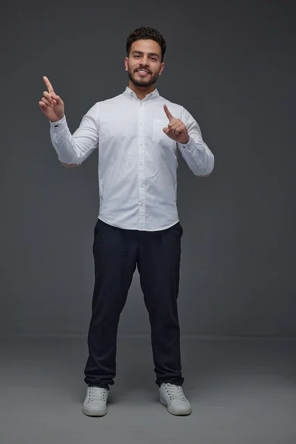 Saudi Man Pointing Upwards in Studio Portrait Background