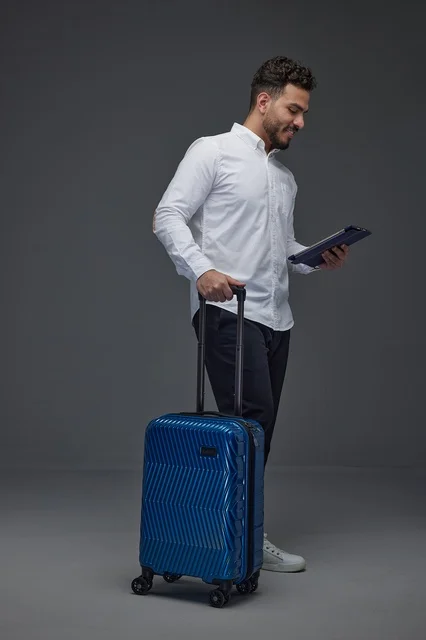 Saudi Traveler with Blue Suitcase and Tablet