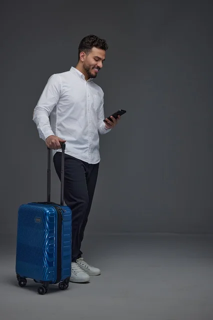 Saudi Male Traveler with Blue Suitcase and Smartphone