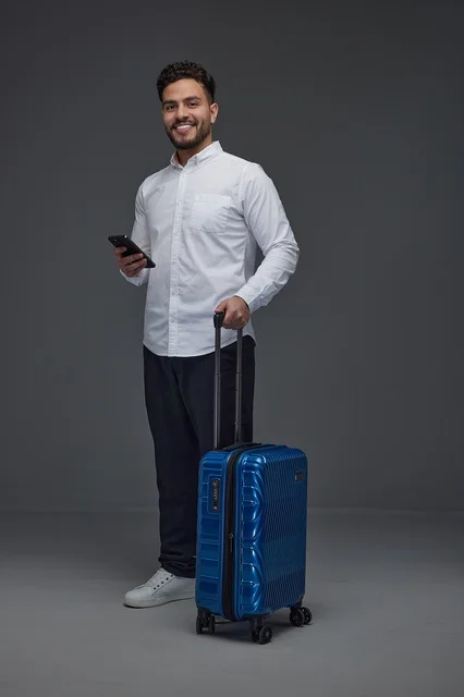 Saudi Man Traveler with Blue Suitcase and Smartphone