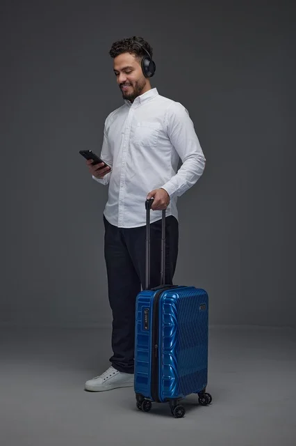 Saudi Traveler with Blue Suitcase and Headphones
