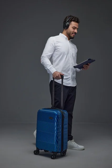 Saudi Traveler Using Tablet with Blue Suitcase Studio