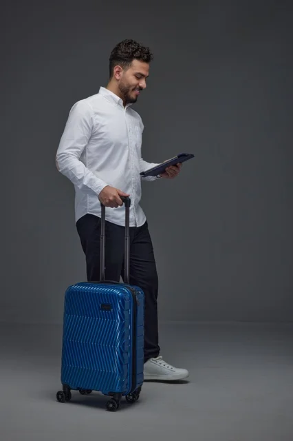 Saudi Traveler with Blue Suitcase and Digital Tablet