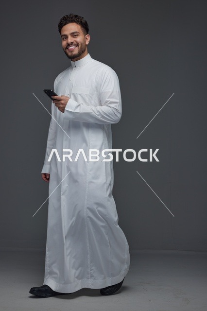 Saudi Man Using Smartphone in Traditional Thobe