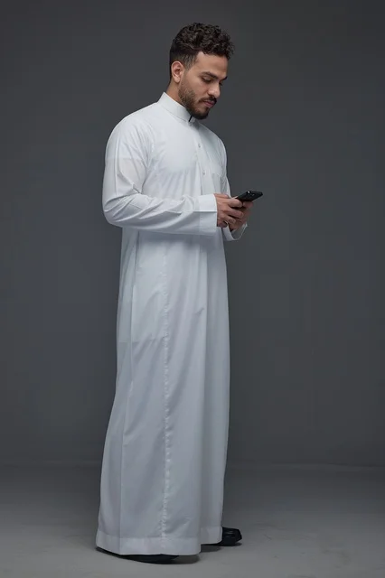Saudi Man in Traditional Thobe Using Smartphone