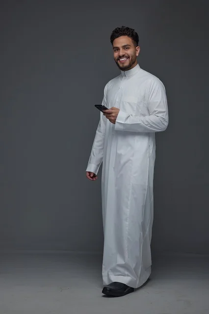 Saudi Man in Traditional Thobe Using Smartphone