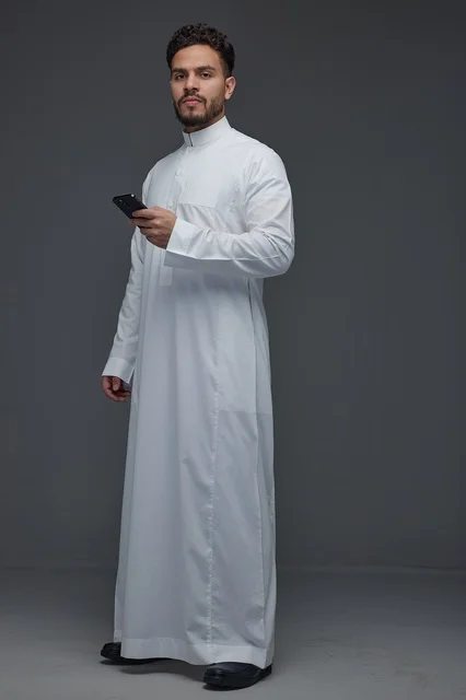 Saudi Man in Traditional Thobe Using Smartphone