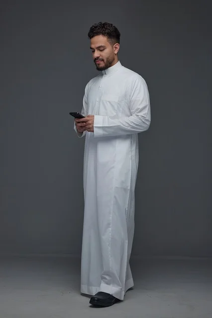 Saudi Man in White Thobe Using Smartphone Studio