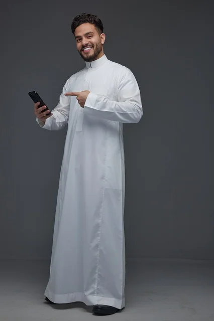 Saudi Man in White Thob Pointing to Smartphone