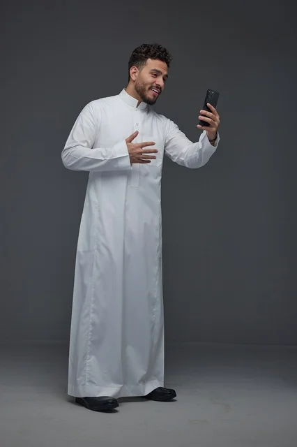 Saudi Man in Traditional Thobe Taking Smartphone Selfie