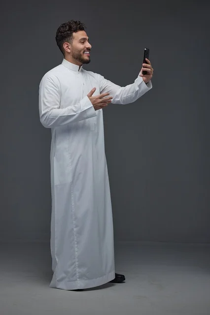 رجل سعودي بالثوب التقليدي يلتقط صورة سيلفي