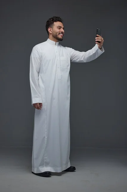 رجل سعودي بالثوب التقليدي يلتقط صورة سيلفي