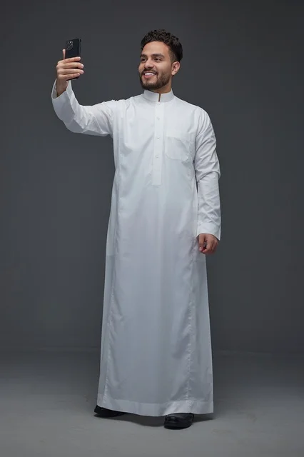 رجل سعودي بالثوب التقليدي يلتقط صورة سيلفي