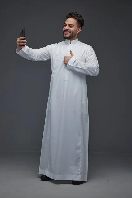 رجل سعودي بالثوب التقليدي يلتقط صورة سيلفي