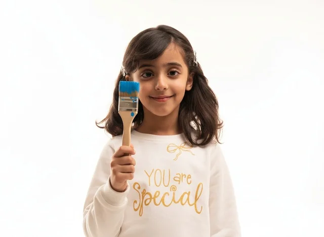 Saudi Girl Holding Paintbrush in Studio Portrait