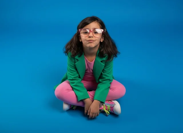 Arab Girl in Green Blazer on Blue Background