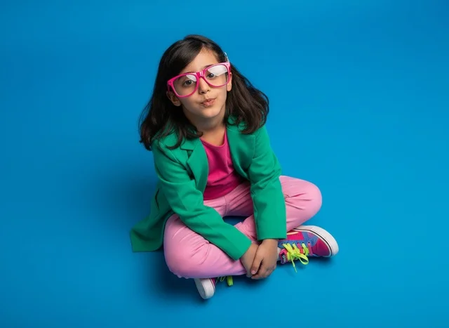 Arab Girl Sitting on Blue Background with Glasses