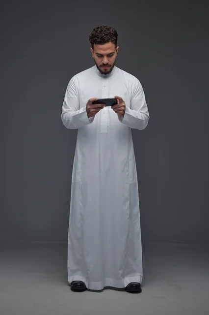 Saudi Man in Thobe Playing Games on Smartphone