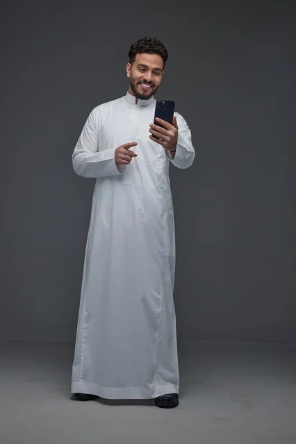 Saudi Man in Thobe Using Smartphone Studio Portrait