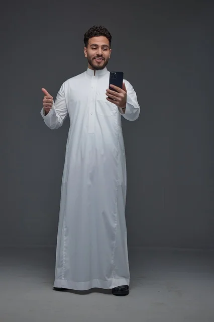 Saudi Man in Thobe Using Smartphone with Thumbs Up