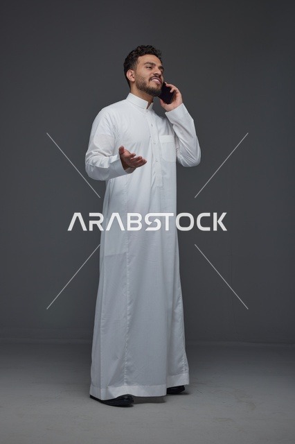 رجل سعودي بالثوب التقليدي يجري مكالمة هاتفية