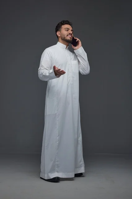 Saudi Man in Thobe Using Smartphone Studio Shot