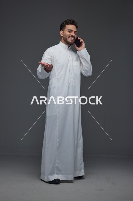 رجل سعودي بالثوب التقليدي يجري مكالمة هاتفية
