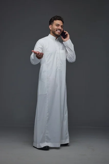 رجل سعودي بالثوب التقليدي يجري مكالمة هاتفية