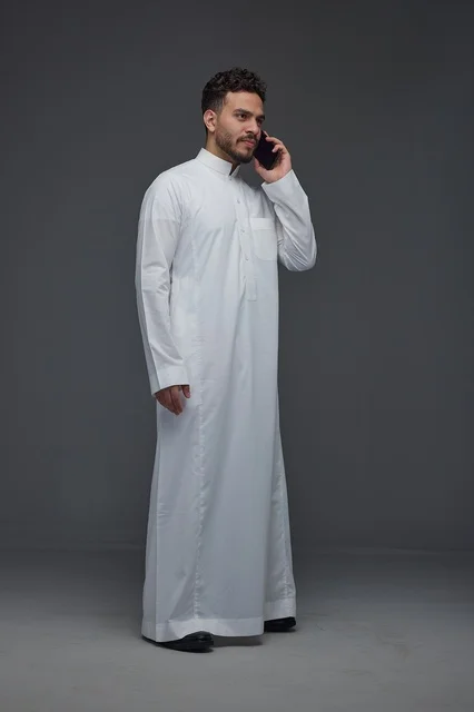Saudi Man in Traditional Thobe Using Smartphone