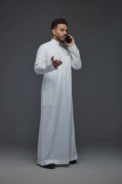 Saudi Man in Traditional Thobe Making a Phone Call