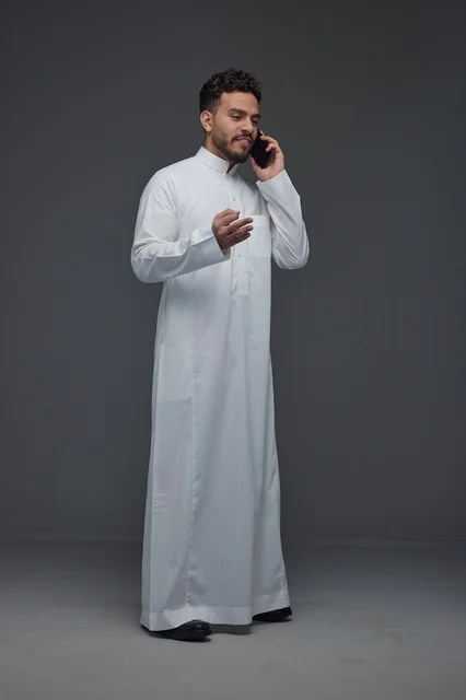 Saudi Man in Traditional Thobe Making a Phone Call