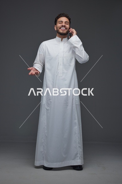 رجل سعودي بالثوب التقليدي يجري مكالمة هاتفية