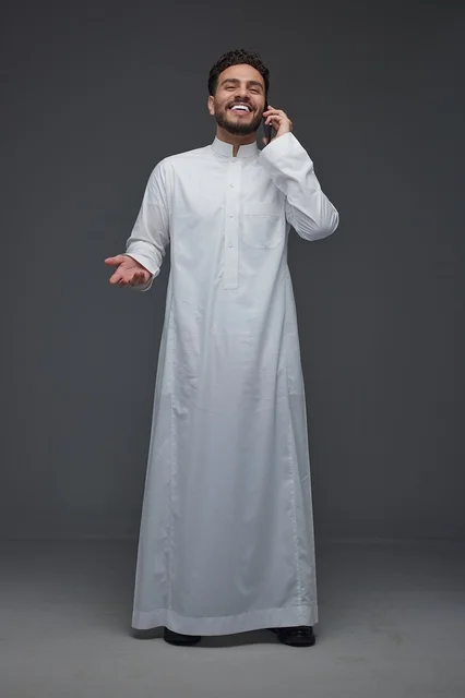 رجل سعودي بالثوب التقليدي يجري مكالمة هاتفية