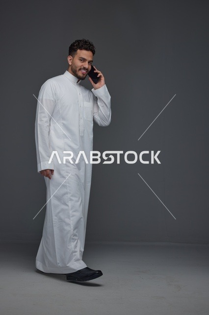 رجل سعودي بالثوب التقليدي يتحدث بالهاتف
