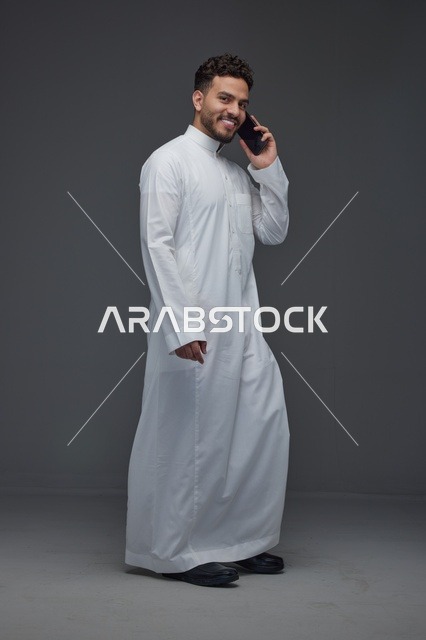 رجل سعودي بالثوب التقليدي يتحدث بالهاتف في استوديو