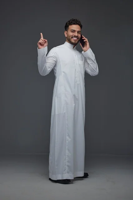 Saudi Man in Traditional Thobe Talking on Smartphone
