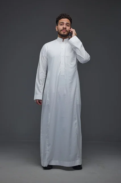رجل سعودي بالثوب التقليدي يجري مكالمة هاتفية