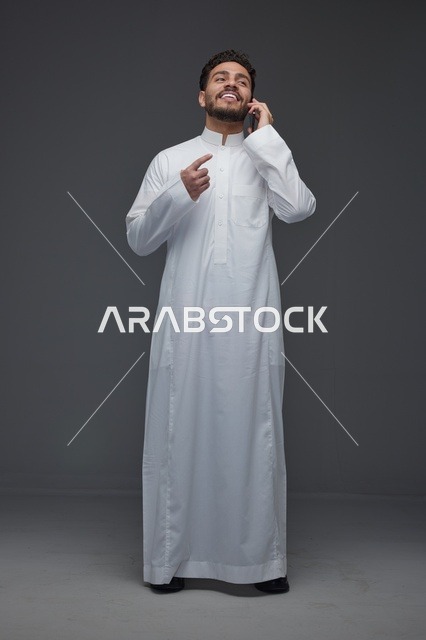 رجل سعودي بالثوب التقليدي يتحدث بالجوال