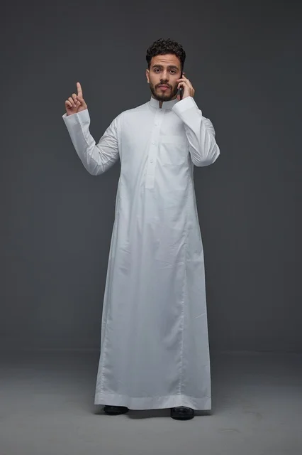 Saudi Man in Thobe Talking on Smartphone Studio Shot