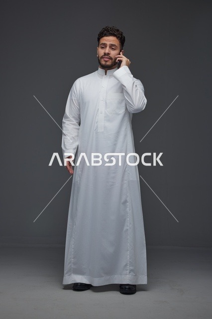 رجل سعودي بالثوب التقليدي يتحدث عبر الجوال