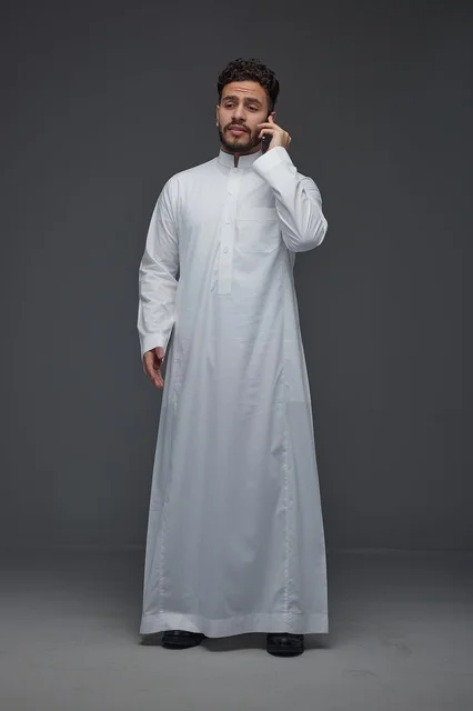 رجل سعودي بالثوب التقليدي يتحدث عبر الجوال