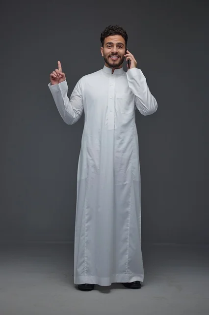 رجل سعودي يتحدث بالهاتف ويشير للأعلى بالثوب التقليدي
