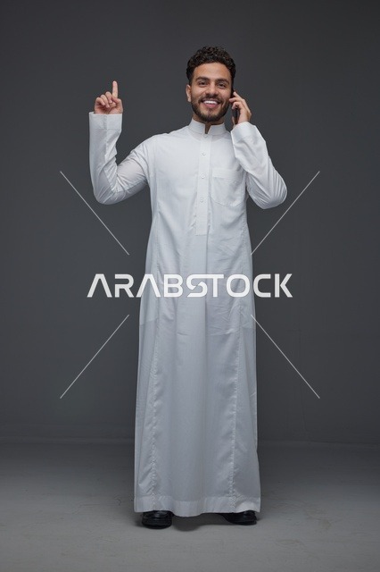 Saudi Man in Thobe Talking on Smartphone Studio