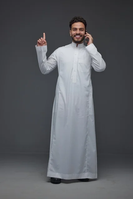 رجل سعودي بالثوب يتحدث بالهاتف الذكي في الاستوديو
